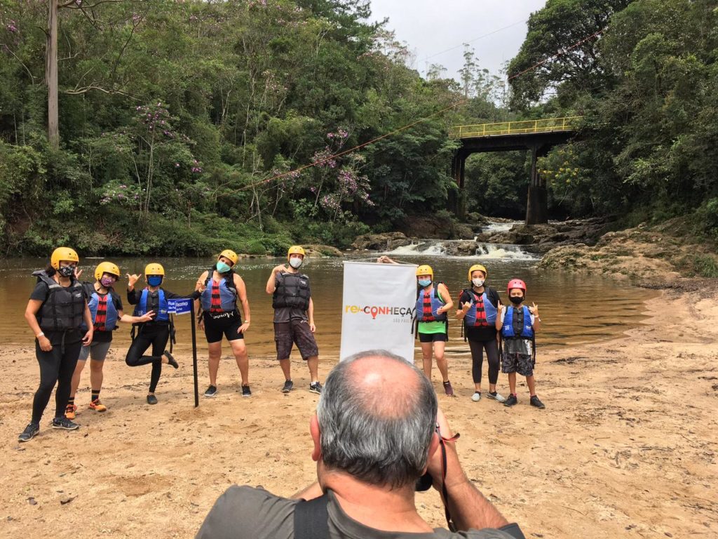 Grupo de turistas pousando para foto antes de fazer o rafting e o boia cross em São Paulo, proximos à cachoeira de Marsillac e participando do Reconheça São Paulo